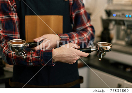 barista in apron grinding coffee in cafe barista in apron grinding coffee in cafe 77335869