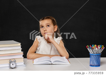 happy schoolgirl sitting at table in the classroom happy schoolgirl sitting at table in the classroom 77335959