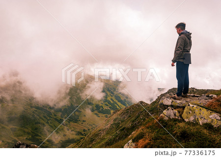 One tourist on the background of the Carpathian mountains, relaxation and enjoyment of nature and solitude. One tourist on the background of the Carpathian mountains, relaxation and enjoyment of nature and solitude. 77336175