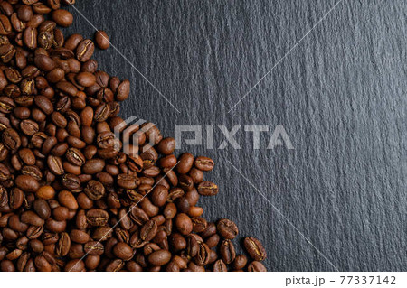 A lot of coffee beans laid out on slate with place for copy space. Top view. 77337142
