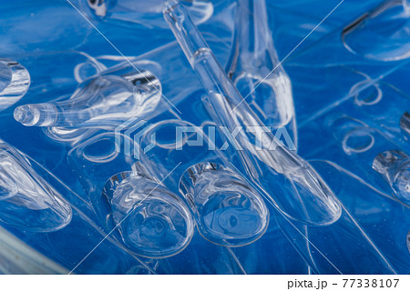 Glass medical ampoule vial for injection. Medicine is liquid sodium chloride with of aqueous solution in ampulla. Close up. Bottles ampule multicolor. 77338107