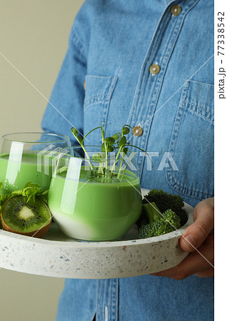 Woman hold tray with glasses of smoothie and ingredients 77338542