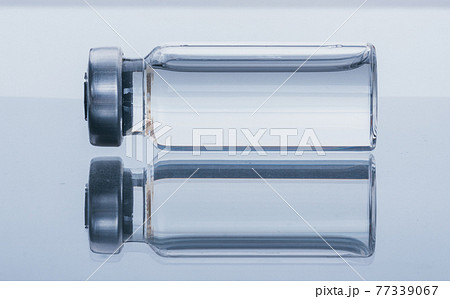 Glass medical ampoule vial for injection. Medicine is dry white drug penicillin powder or liquid with of aqueous solution in ampulla. Close up. Glass medical ampoule vial for injection. Medicine is dry white drug penicillin powder or liquid with of aqueous solution in ampulla. Close up. 77339067