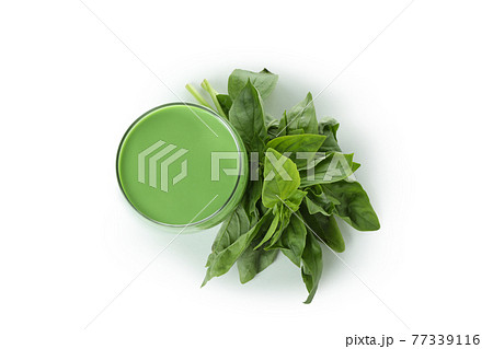Glass of green smoothie and spinach isolated on white background 77339116