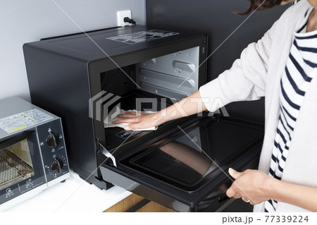 電子レンジを掃除する女性 77339224