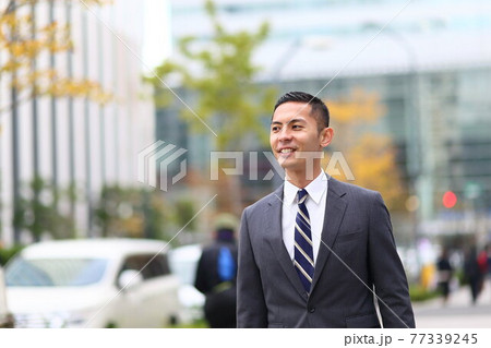 制服　時計　会社員　新入社員　働く人　ビジネス　屋外　若い男性　ビル　コロナ　営業　コピースペース 77339245