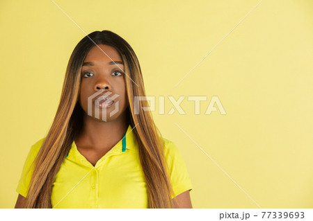 Portrait of African young woman posing isolated on yellow background. 77339693