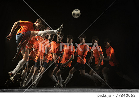 Young male football soccer player in motion and action in mixed light on dark background. Young male football soccer player in motion and action in mixed light on dark background. 77340665