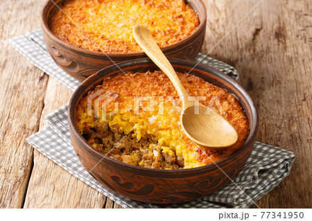 Chilean shepherds pie, pastel choclo spiced ground beef with a pureed corn crust closeup in the pots. Horizontal 77341950