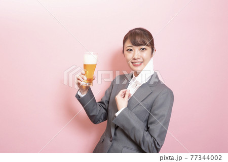 マスクを外してビールをもつ女性 77344002