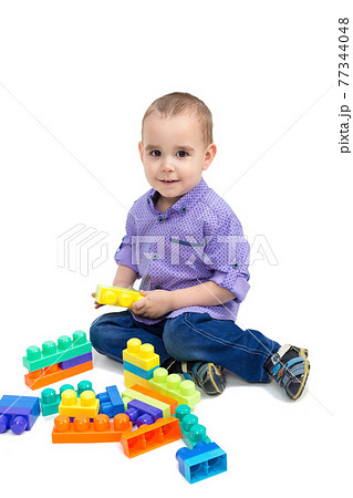 Cheerful child is playing with toys on the floor. Isolate Cheerful child is playing with toys on the floor. Isolate 77344048