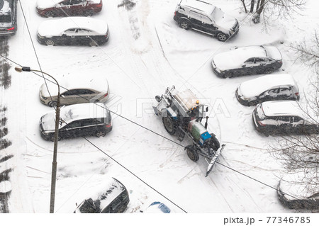 road cleaning in parking area with tractor in snow road cleaning in parking area with tractor in snow 77346785