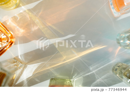 Multicolor perfume bottle reflections on white background 77346944