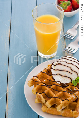 Waffles with ice cream on wooden table 77347446
