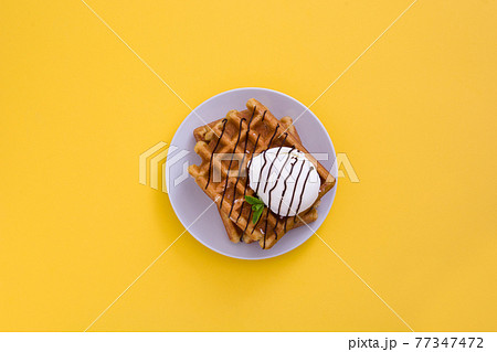 Waffles with ice cream on yellow background 77347472