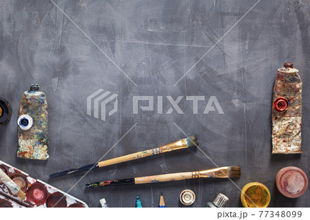 Used paintbrush and tubes with painter tools at abstract table background texture. Used paintbrush and tubes with painter tools at abstract table background texture. 77348099