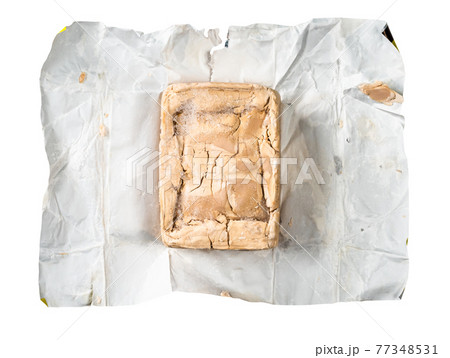 unwrapped fresh compressed yeast on foil cutout 77348531
