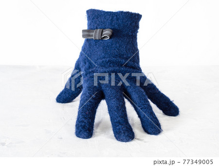blue woolen glove with bow tie stands on board blue woolen glove with bow tie stands on board 77349005