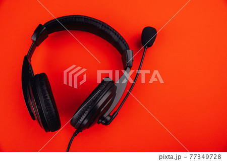 Black headphones isolated on red background 77349728