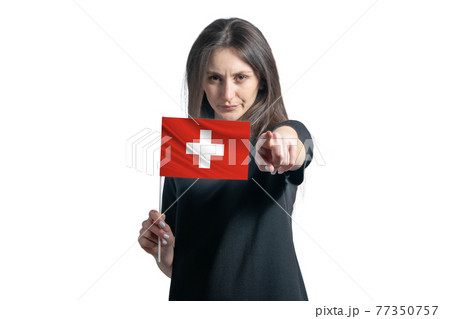 Happy young white woman holding flag of Switzerland and points forward in front of him isolated on a white background Happy young white woman holding flag of Switzerland and points forward in front of him isolated on a white background 77350757