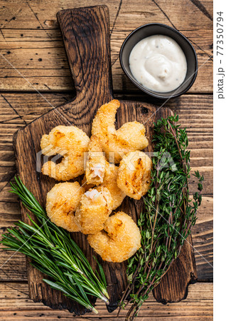Fried Crispy Shrimps Prawns on a wooden board with sauce. wooden background. Top view Fried Crispy Shrimps Prawns on a wooden board with sauce. wooden background. Top view 77350794