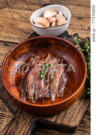 Canned Anchovies fish fillet in a wooden bowl. wooden background. Top view Canned Anchovies fish fillet in a wooden bowl. wooden background. Top view 77350892