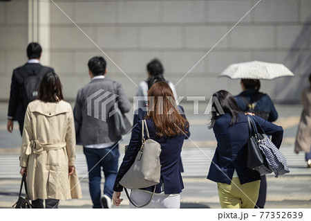 朝の通勤をする歩く女性の後ろ姿 77352639