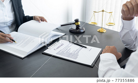 law,libra scale and hammer on the table, 2 lawyers are discussing about contract paper, law matters determination 77355886