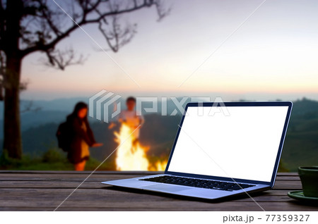 Mock up laptop computer wooden table near campfire and tent. Mock up laptop computer wooden table near campfire and tent. 77359327