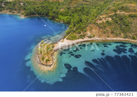 Aerial view of clear turquoise water near the rocky coast of the Aegean Sea, Turkey. Aerial view of clear turquoise water near the rocky coast of the Aegean Sea, Turkey. 77363421