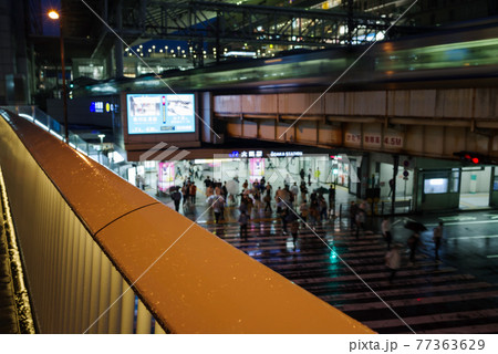 阪急阪神連絡デッキ・梅田新歩道橋の雨に濡れる欄干と大阪駅前の横断歩道の風景 77363629
