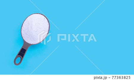 Laundry concept, Detergent powder in measuring spoon for clothes washing on blue Laundry concept, Detergent powder in measuring spoon for clothes washing on blue 77363825
