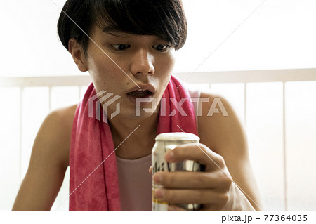 部屋でビールを飲む男性 77364035