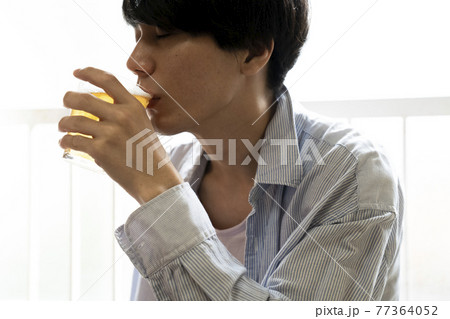 部屋でビールを飲む男性 77364052