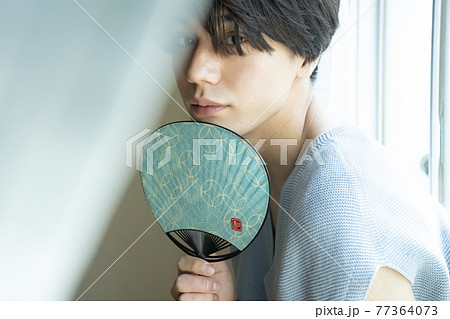うちわであおぐ男性 77364073