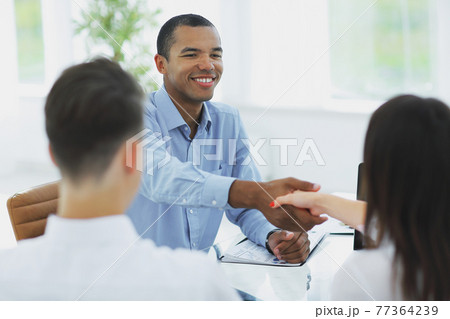 closeup.handshake Manager and the client in the office 77364239