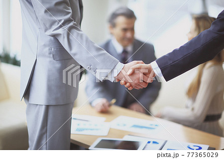 close up.handshake of business partners on the background of the workplace 77365029