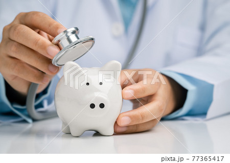 Doctor using a stethoscope to check the piggy bank financial check-up, Concept check financial sustainability of financial status. Doctor using a stethoscope to check the piggy bank financial check-up, Concept check financial sustainability of financial status. 77365417