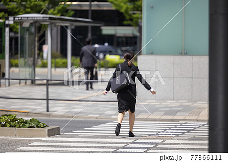 走って横断歩道を渡るスーツの女子学生 77366111