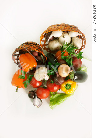 mushrooms and a variety of fresh vegetables in a wicker basket.i 77366380