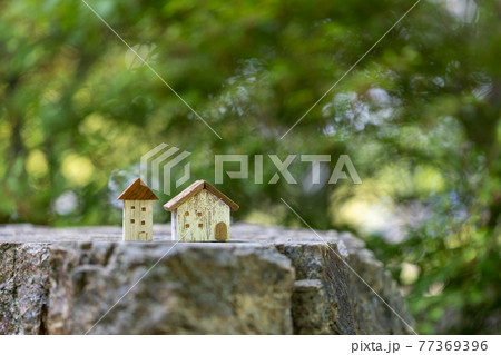 2軒の小さい可愛い木製ののおうち（新緑背景） 77369396