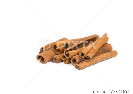 Stack of cinnamon sticks isolated on white background. Closeup, cinnamon sticks a lot. 77370652
