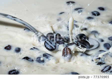 Coffee beans falling on the milk splash. Coffee beans falling on the milk splash. 77370965