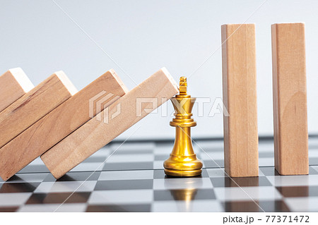 wooden Blocks or Dominoes falling to golden Chess King figure. Business, Risk Management, Solution, economic regression, Insurance wooden Blocks or Dominoes falling to golden Chess King figure. Business, Risk Management, Solution, economic regression, Insurance 77371472