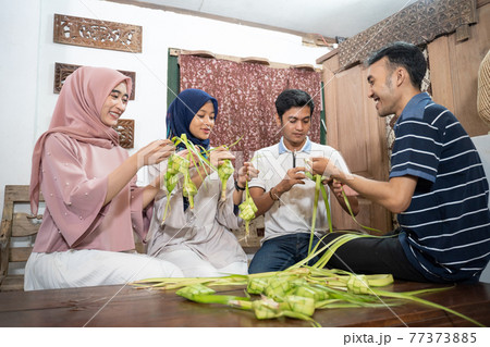 muslim family and friend making ketupat for eid fitr mubarak 77373885