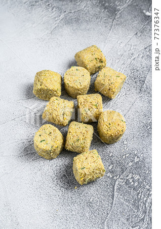 Raw falafel balls on a kitchen table. White background. Top view 77376347