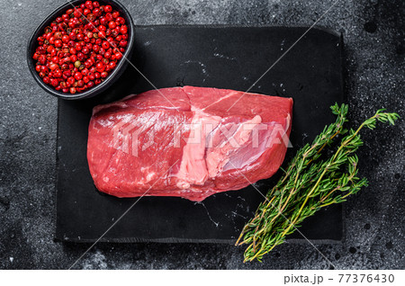 Raw lamb meat leg steak on a stone board. Black background. Top view Raw lamb meat leg steak on a stone board. Black background. Top view 77376430