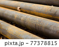 Rusty metal pipes for water, lie diagonally on the ground 77378815