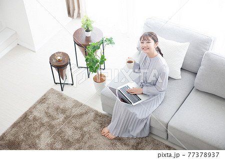 若い女性　リビング　ノートパソコン 77378937