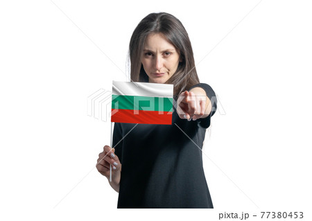 Happy young white woman holding flag of Bulgaria and points forward in front of him isolated on a white background Happy young white woman holding flag of Bulgaria and points forward in front of him isolated on a white background 77380453